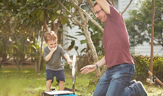 Family activity of a father and his son catching a fish 