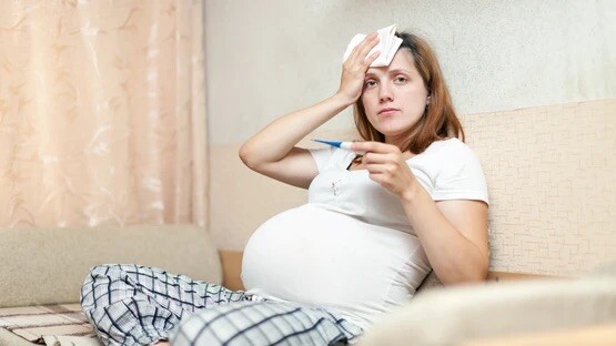 pregnant-woman-with-thermometer-living-room (1).jpg