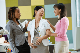 Expectant woman embracing pregnancy fashion while interacting with her colleagues