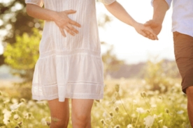 A pregnant woman holding her husband's hand while travelling