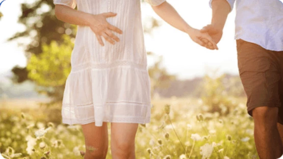 A pregnant woman holding her husband's hand while travelling