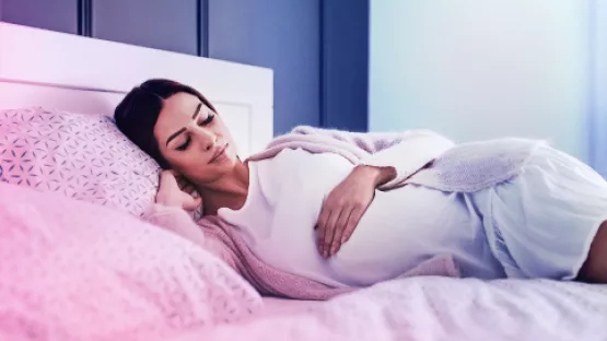 Pregnant woman in a comfortable sleeping position, deep in slumber, experiencing vivid dreams