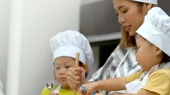 A mother baking with 2 children