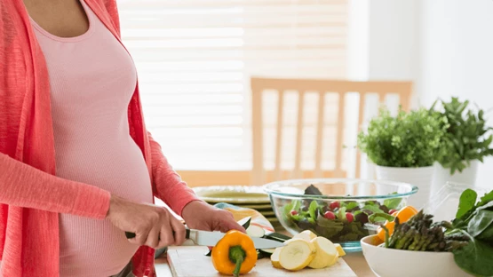 Pregnant woman preparing nutrition-based meal