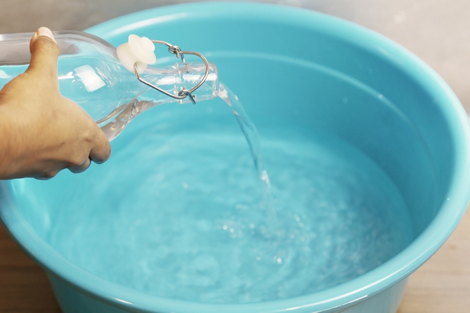 Pour the warm water from jug into the container