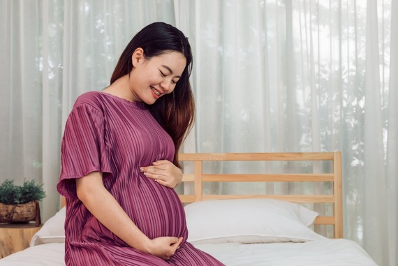 portrait-young-adult-asian-pregnant-woman-touching-her-belly-with-love-home Large.jpeg